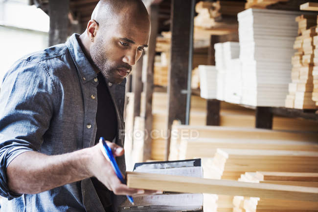 Homem segurando pasta e verificação de madeira — Fotografia de Stock