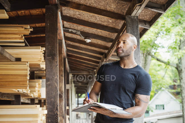 Homem segurando pasta e verificação de madeira — Fotografia de Stock