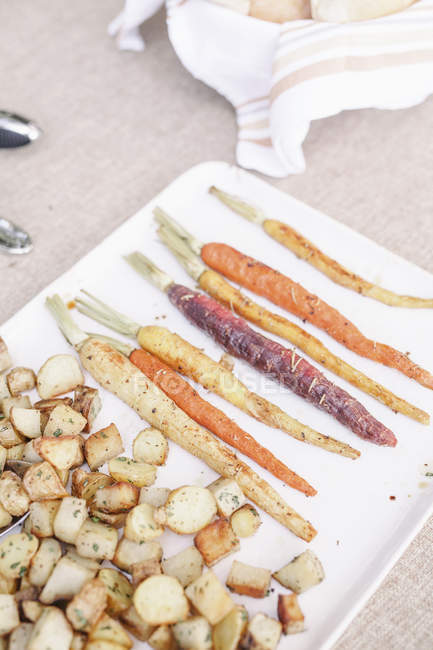 Plato de zanahorias y patatas a la parrilla - foto de stock