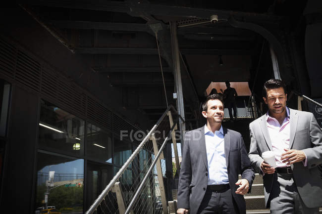 Hommes d'affaires marchant dans l'escalier — Photo de stock