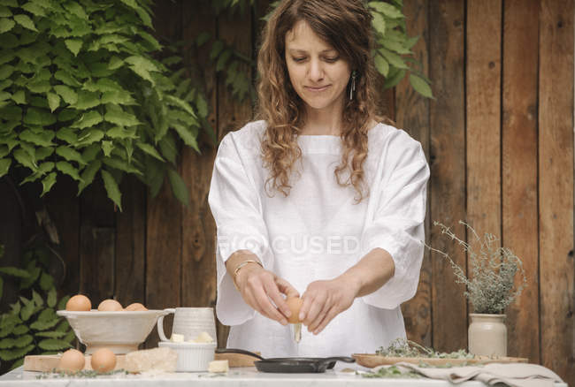 Mujer preparando huevos para el desayuno. - foto de stock