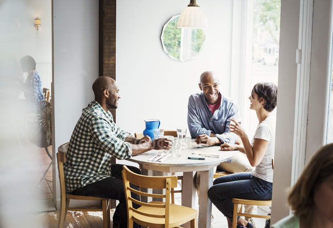 Hommes et femmes déjeunant au café — Photo de stock