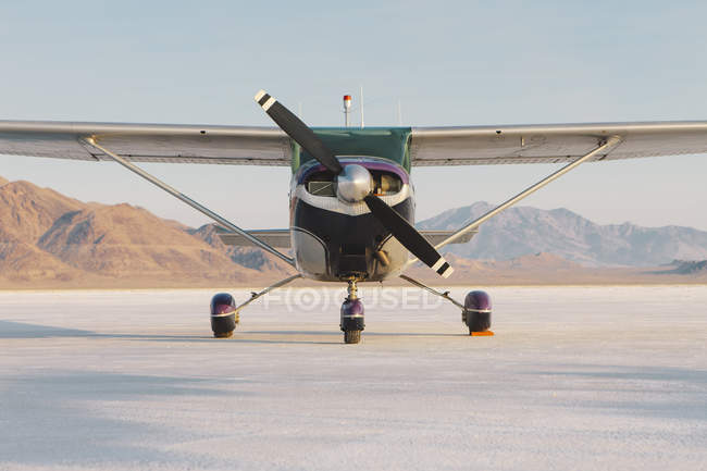 Small airplane parked on salt flats — Stock Photo