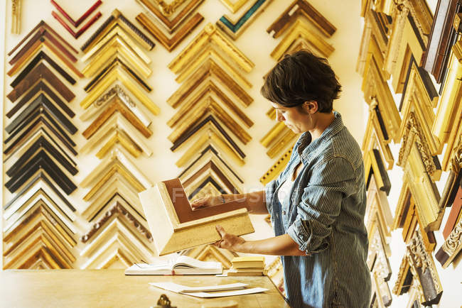 Woman working at picture framers — Stock Photo