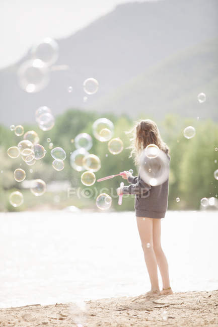 Adolescente chica rodeada de burbujas de jabón - foto de stock