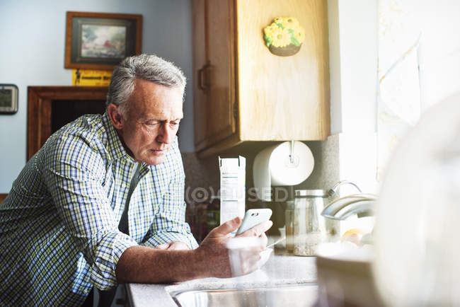 Hombre mayor usando un teléfono móvil . - foto de stock