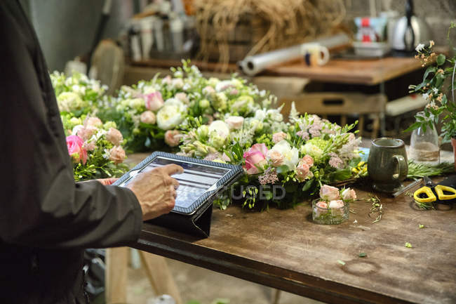 Флорист використовує цифровий планшет — стокове фото
