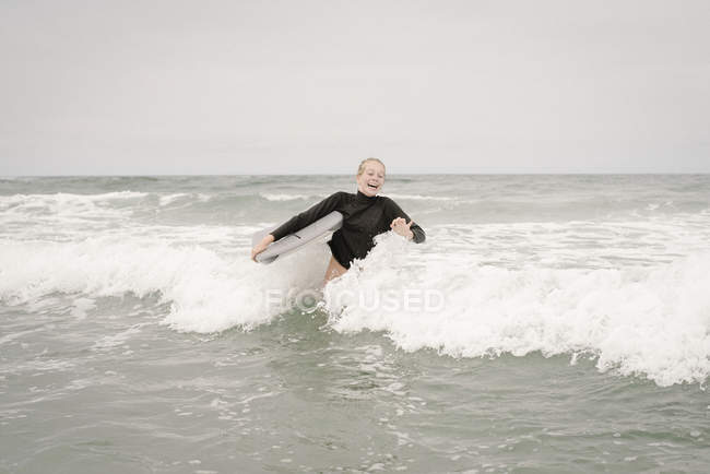 Girl bodyboarding in ocean — Stock Photo