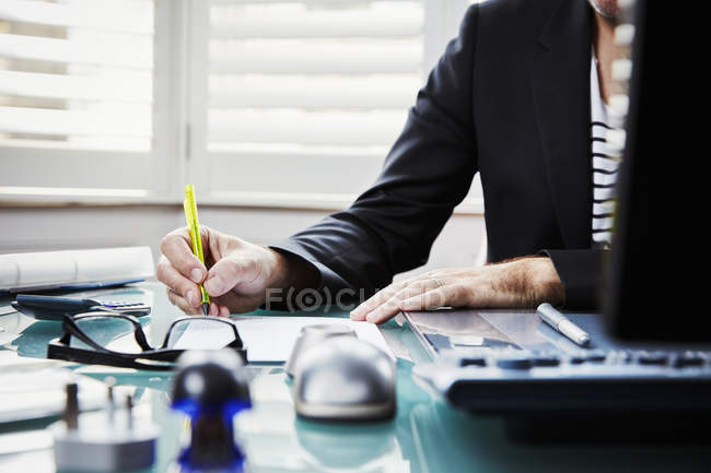 Hombre de negocios sentado en el escritorio en una oficina - foto de stock
