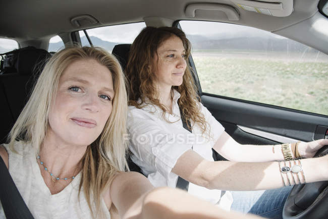 Mujeres en un coche en un viaje por carretera - foto de stock