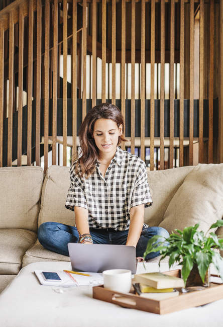 Woman on a sofa with a laptop computer — Stock Photo