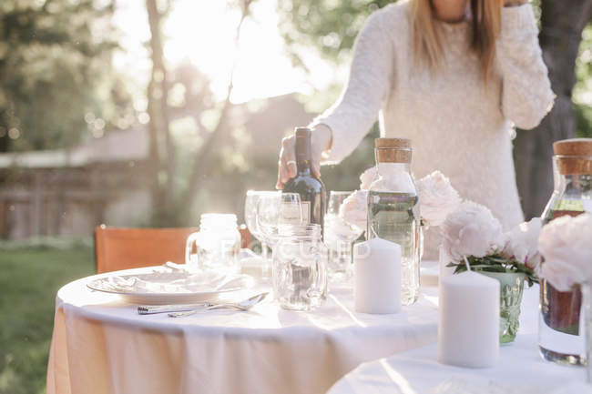 Frau deckt Tisch im Garten — Stockfoto