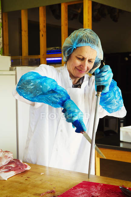 Femme travaillant dans la boucherie — Photo de stock