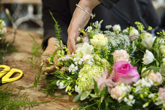 Frau arbeitet an einem Blumengesteck — Stockfoto