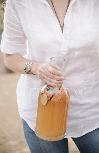 Mulher segurando uma grande garrafa de vidro — Fotografia de Stock