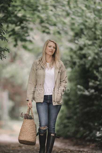 Mulher carregando cesta com flores . — Fotografia de Stock
