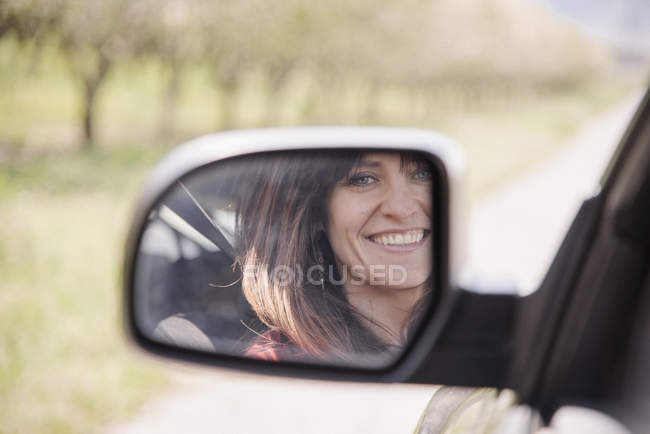 Femme dans une voiture, souriante — Photo de stock
