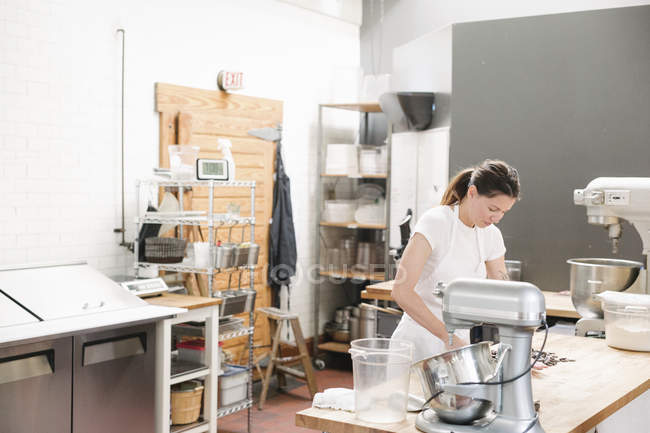 Жінка стоїть на робочому лічильнику в пекарні — стокове фото