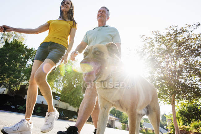 Старшая пара выгуливает собаку — стоковое фото