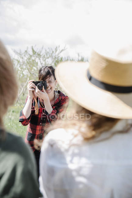 Fotógrafo tomando fotos de dos mujeres - foto de stock