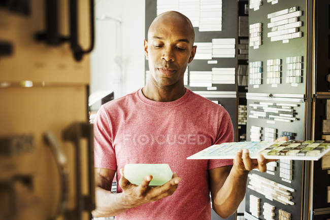 Hombre mirando mercancía en la tienda de diseño - foto de stock