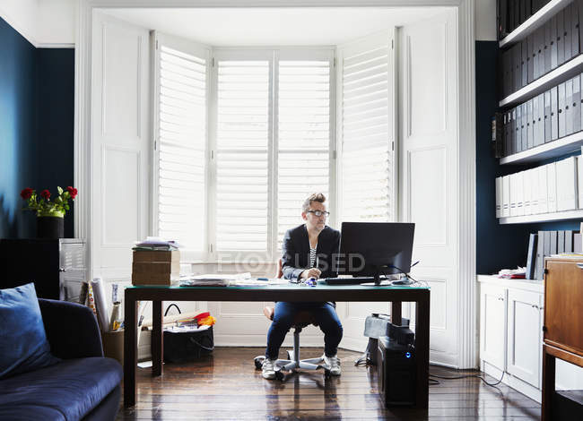 Uomo d'affari seduto alla scrivania in vetrata — Foto stock