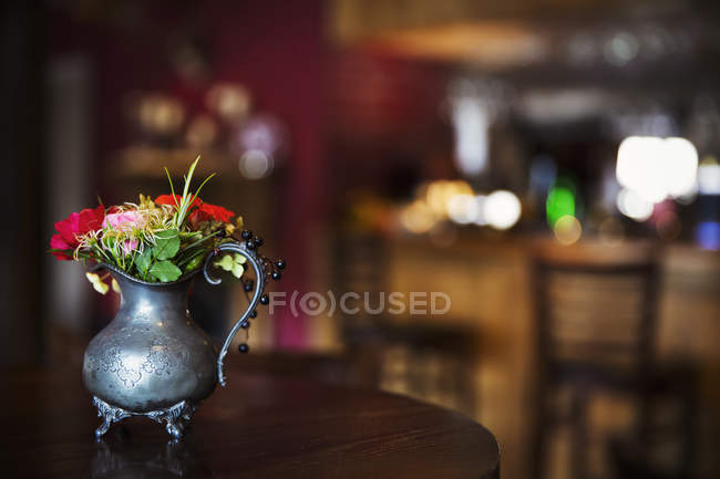 Pewter jug with bunch of flowers — Stock Photo