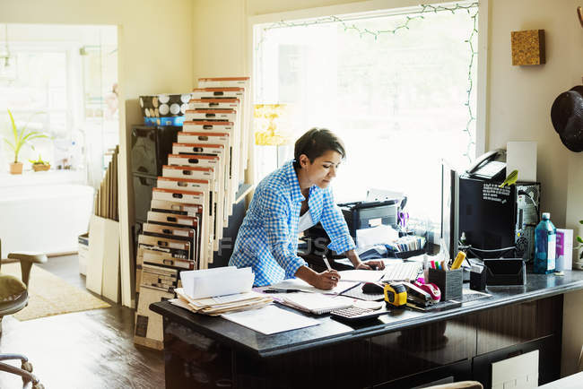 Женщина, работающая за столом в студии интерьера — стоковое фото