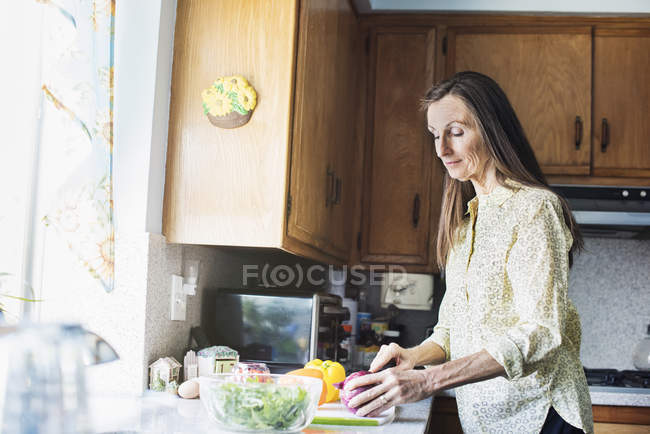 Seniorin bereitet Essen zu. — Stockfoto