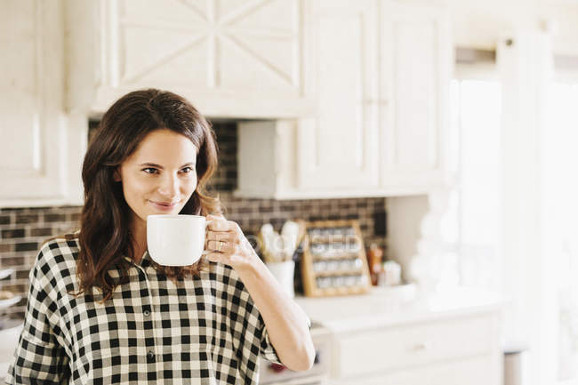 Woman drinking from a mug. — Stock Photo