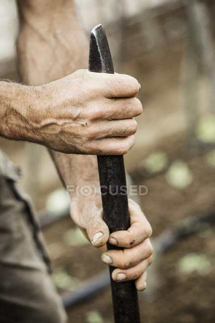 Homme tenant un dibber en métal — Photo de stock