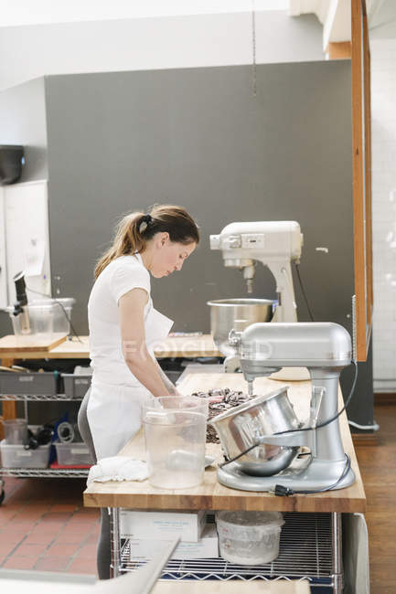 Mujer en un mostrador de trabajo en una panadería . - foto de stock