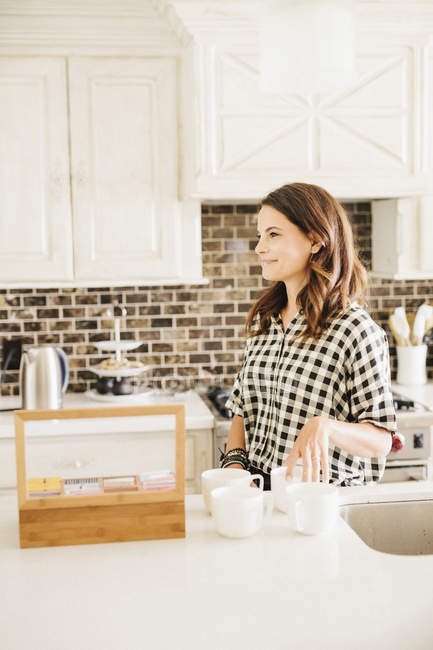 Frau in der Küche und kocht einen Tee. — Stockfoto
