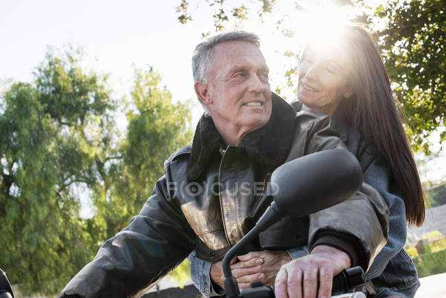 Couple aîné faisant un tour en moto — Photo de stock