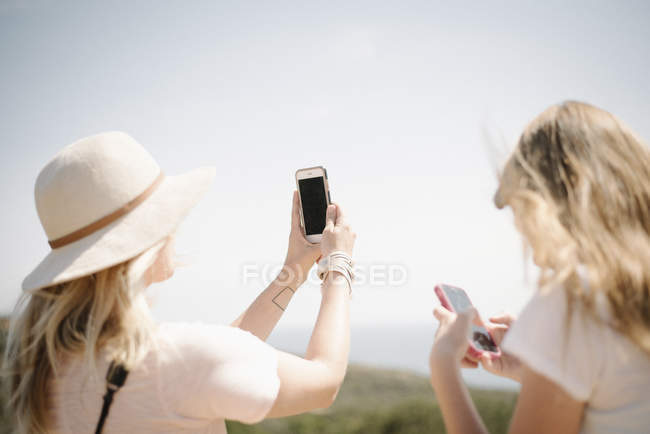 Mujer y adolescente tomando fotos - foto de stock