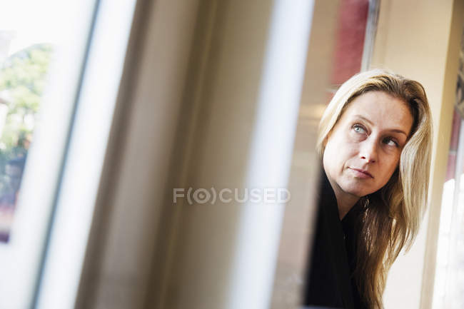 Mujer rubia mirando hacia los lados - foto de stock