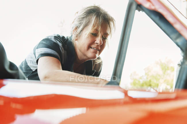 Reife Frau repariert ein Auto — Stockfoto