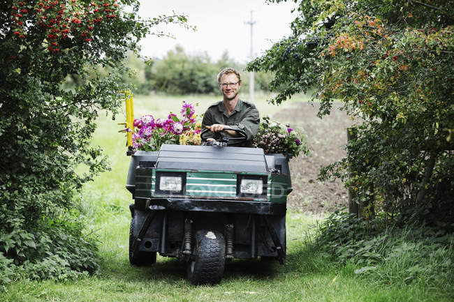 Uomo alla guida di un piccolo veicolo da giardino — Foto stock