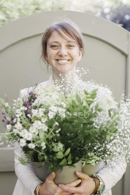 Frau trägt einen Strauß weißer Blumen. — Stockfoto