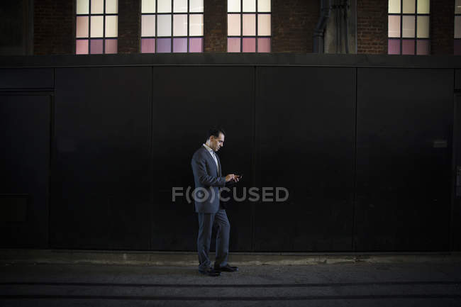 Uomo d'affari in piedi in ombra sulla strada della città — Foto stock