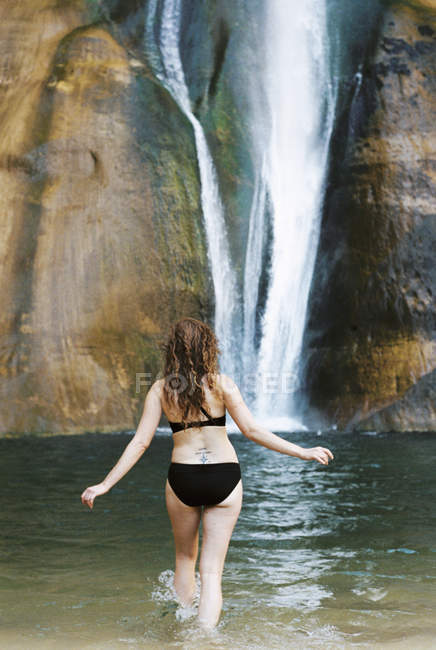 Mulher de biquíni preto na cachoeira — Fotografia de Stock