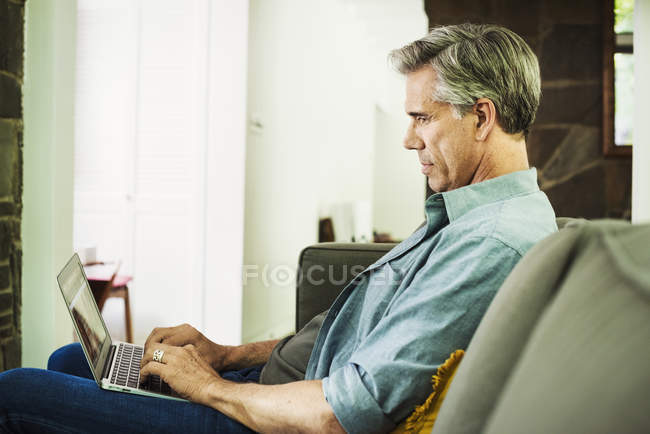 Hombre usando un portátil. - foto de stock