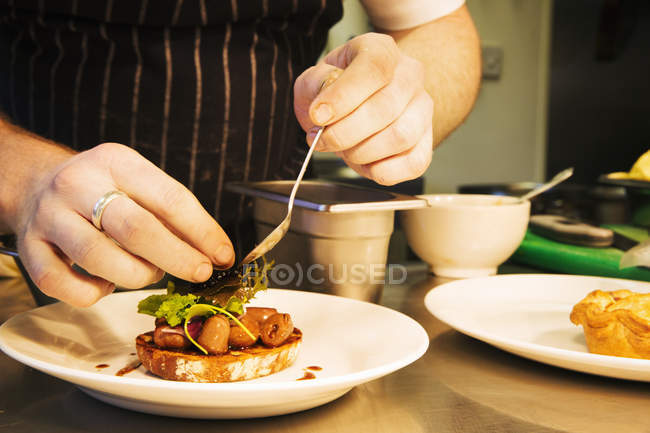 Chef plating up a dish — Stock Photo