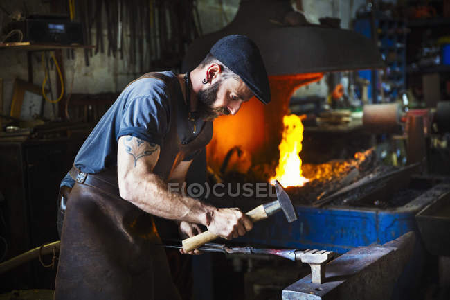 Blacksmith uses complex tools — Stock Photo
