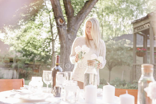 Frau deckt Tisch im Garten — Stockfoto