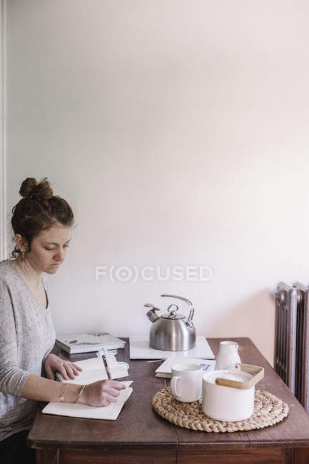Woman writing in diary — Stock Photo