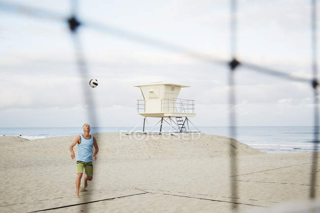 Mature man playing beach volleyball. — Stock Photo