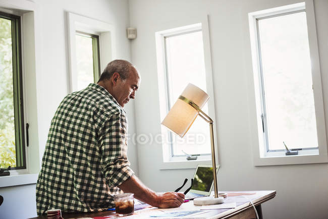 Hombre usando un ordenador portátil en casa - foto de stock