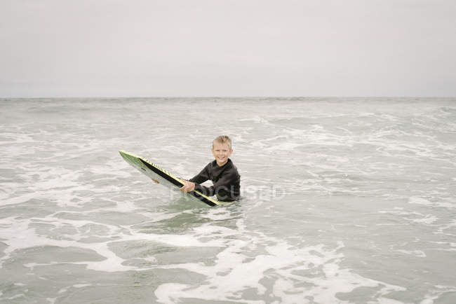 Boy bodyboarding en el océano - foto de stock