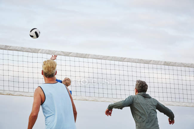 Uomini maturi che giocano a beach volley
. — Foto stock